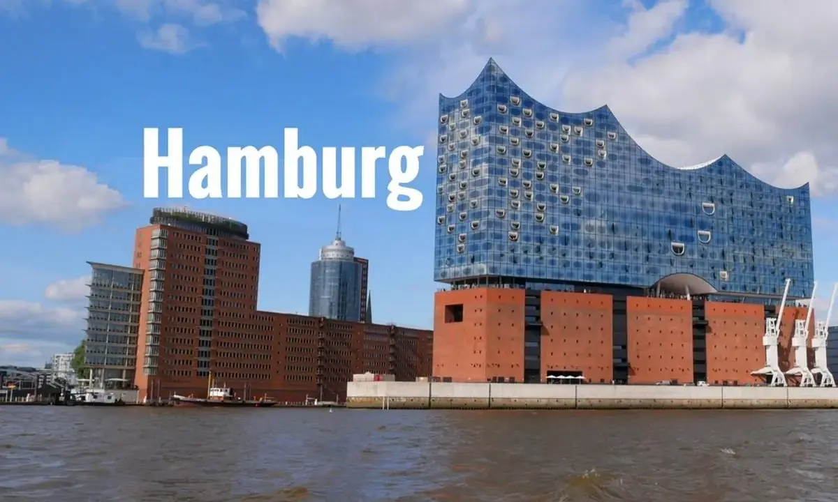 Widok na nowoczesne budynki i port w Hamburgu. Jedna z głównych hamburg atrakcje, filharmonia Elbphilharmonie, lśni w słońcu.