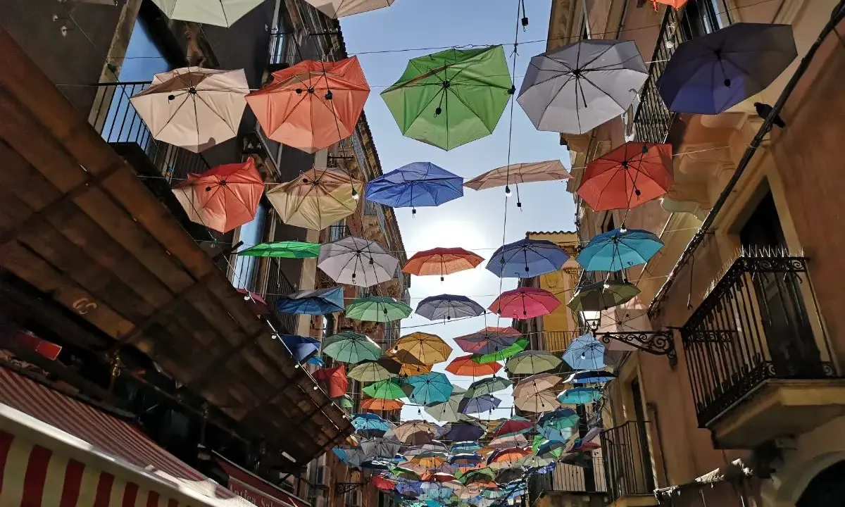 Kolorowe parasole nad ulicą w Katanii. Wspaniała instalacja, którą warto zobaczyć, tworzy magiczną atmosferę.