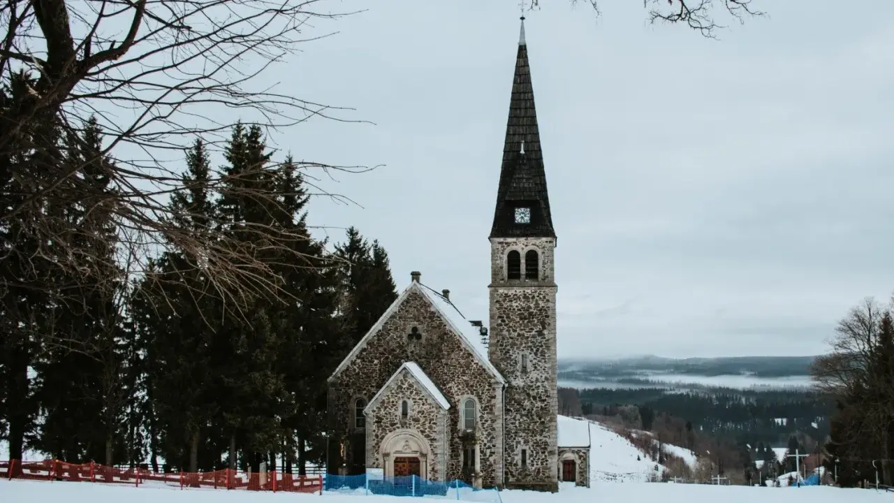 Kamienna świątynia na tle zimowego krajobrazu. Wokół śnieg i sosny. To z pewnością jedne z zieleniec atrakcje.