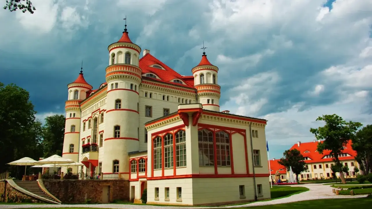 Pałac Wojanów, z jego wieżyczkami i czerwonym dachem, kryje bogatą historię. Otoczony zielenią, zaprasza do odkrywania jego tajemnic.