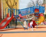 Kolorowy plac zabaw w Ełku oferuje mnóstwo atrakcji dla dzieci: zjeżdżalnie, ścianki wspinaczkowe i mnóstwo miejsca do biegania.