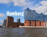 Widok na nowoczesne budynki i port w Hamburgu. Jedna z głównych hamburg atrakcje, filharmonia Elbphilharmonie, lśni w słońcu.