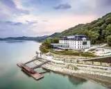 Elegancki hotel nad jeziorem, idealny na romantyczne miejsca w Polsce. Widok na spokojną taflę wody i zielone wzgórza.