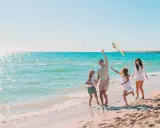 Rodzina puszcza latawiec na plaży. Idealne miejsce, gdzie nad morze z dziećmi tanio i radośnie spędza czas.