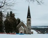Kamienna świątynia na tle zimowego krajobrazu. Wokół śnieg i sosny. To z pewnością jedne z zieleniec atrakcje.