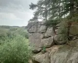 Skalny krajobraz w Polsce, z formacjami skalnymi przypominającymi miasto. Drzewa i zieleń otaczają skalne miasto.