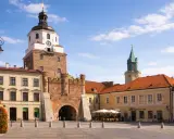 Brama Krakowska w Lublinie, symbol miasta, zaprasza do odkrywania lublin nietypowe atrakcje. W tle wieża zamkowa i kamienice.