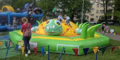 Dzieci bawią się na dmuchanej gąsienicy, jednej z wielu atrakcji na Dzień Dziecka.