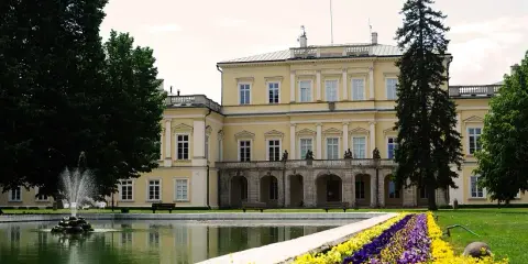 Pałac Czartoryskich w Puławach, z fontanną i kwiecistą rabatą. Ciekawostki o tym miejscu czekają na odkrycie.