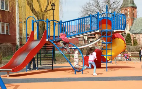 Kolorowy plac zabaw w Ełku oferuje mnóstwo atrakcji dla dzieci: zjeżdżalnie, ścianki wspinaczkowe i mnóstwo miejsca do biegania.