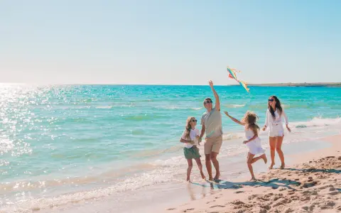 Rodzina puszcza latawiec na plaży. Idealne miejsce, gdzie nad morze z dziećmi tanio i radośnie spędza czas.