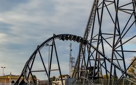 Pasażerowie jadą na wagonikach największego rollercoastera w Europie, który pnie się po stalowej konstrukcji.
