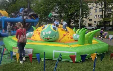 Dzieci bawią się na dmuchanej gąsienicy, jednej z wielu atrakcji na Dzień Dziecka.