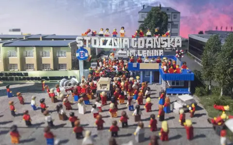 Miniaturowa scena z Klockoland Kraków przedstawiająca tłum ludzi pod bramą z napisem "Stocznia Gdańska im. Lenina".
