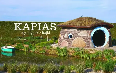 Bajkowy domek z kamienia i cegły, porośnięty trawą dach, otoczony zielenią i stawem. Ciekawe ogrody jak z bajki.