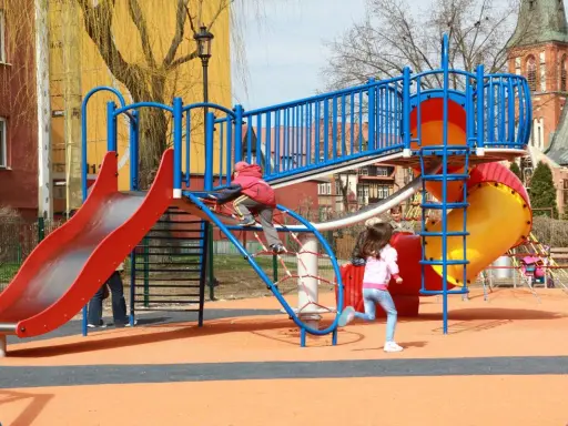 Kolorowy plac zabaw w Ełku oferuje mnóstwo atrakcji dla dzieci: zjeżdżalnie, ścianki wspinaczkowe i mnóstwo miejsca do biegania.