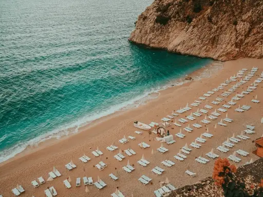 Piękna plaża z turkusową wodą i rzędami leżaków. Idealne miejsce, by zastanowić się, gdzie na wakacje.