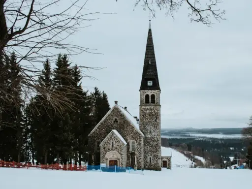 Kamienna świątynia na tle zimowego krajobrazu. Wokół śnieg i sosny. To z pewnością jedne z zieleniec atrakcje.