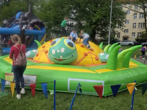 Dzieci bawią się na dmuchanej gąsienicy, jednej z wielu atrakcji na Dzień Dziecka.