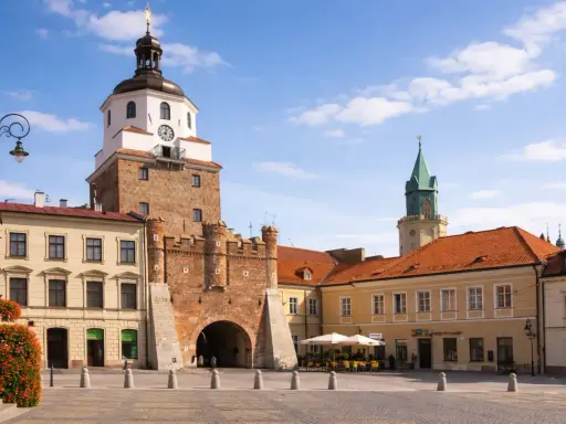 Brama Krakowska w Lublinie, symbol miasta, zaprasza do odkrywania lublin nietypowe atrakcje. W tle wieża zamkowa i kamienice.