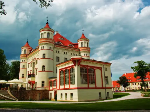 Pałac Wojanów, z jego wieżyczkami i czerwonym dachem, kryje bogatą historię. Otoczony zielenią, zaprasza do odkrywania jego tajemnic.