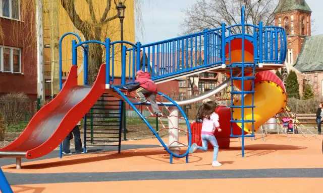 Kolorowy plac zabaw w Ełku oferuje mnóstwo atrakcji dla dzieci: zjeżdżalnie, ścianki wspinaczkowe i mnóstwo miejsca do biegania.