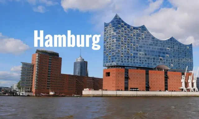 Widok na nowoczesne budynki i port w Hamburgu. Jedna z głównych hamburg atrakcje, filharmonia Elbphilharmonie, lśni w słońcu.