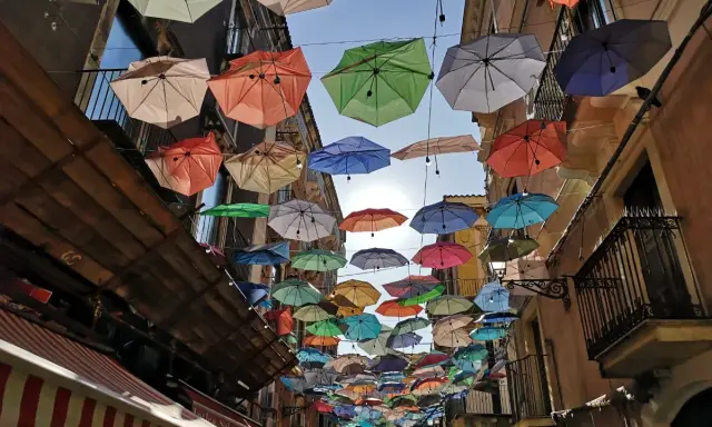 Kolorowe parasole nad ulicą w Katanii. Wspaniała instalacja, którą warto zobaczyć, tworzy magiczną atmosferę.