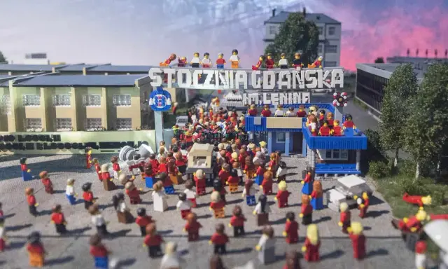 Miniaturowa scena z Klockoland Kraków przedstawiająca tłum ludzi pod bramą z napisem "Stocznia Gdańska im. Lenina".