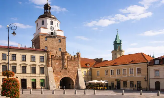 Brama Krakowska w Lublinie, symbol miasta, zaprasza do odkrywania lublin nietypowe atrakcje. W tle wieża zamkowa i kamienice.
