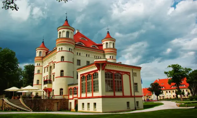 Pałac Wojanów, z jego wieżyczkami i czerwonym dachem, kryje bogatą historię. Otoczony zielenią, zaprasza do odkrywania jego tajemnic.