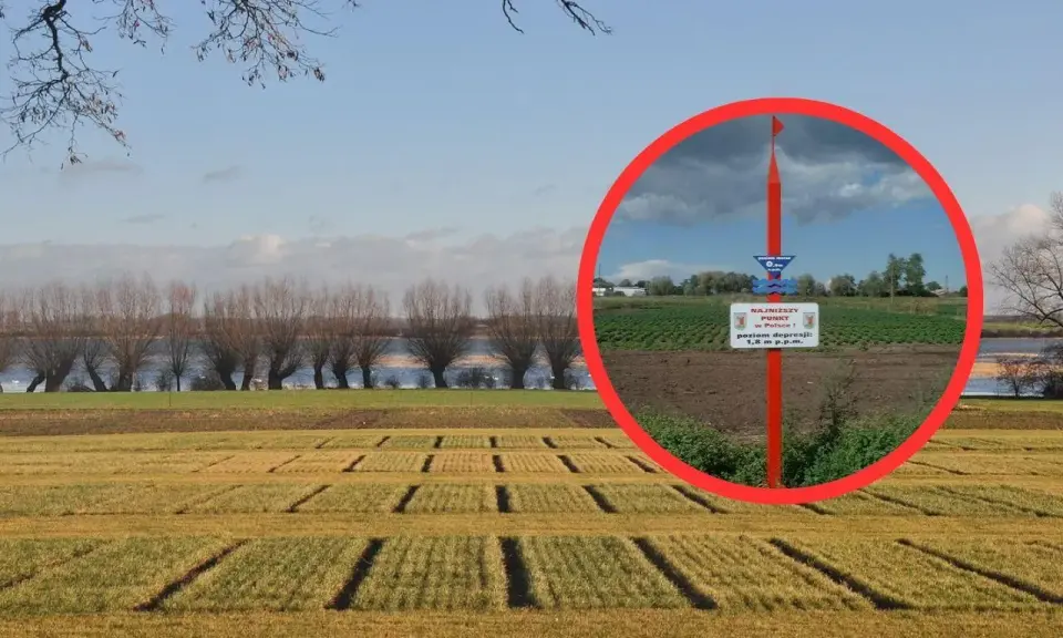 Najniższy punkt w Polsce, oznaczony tablicą informującą o poziomie depresji 1,8 m p.p.m., na tle pola i rzeki.