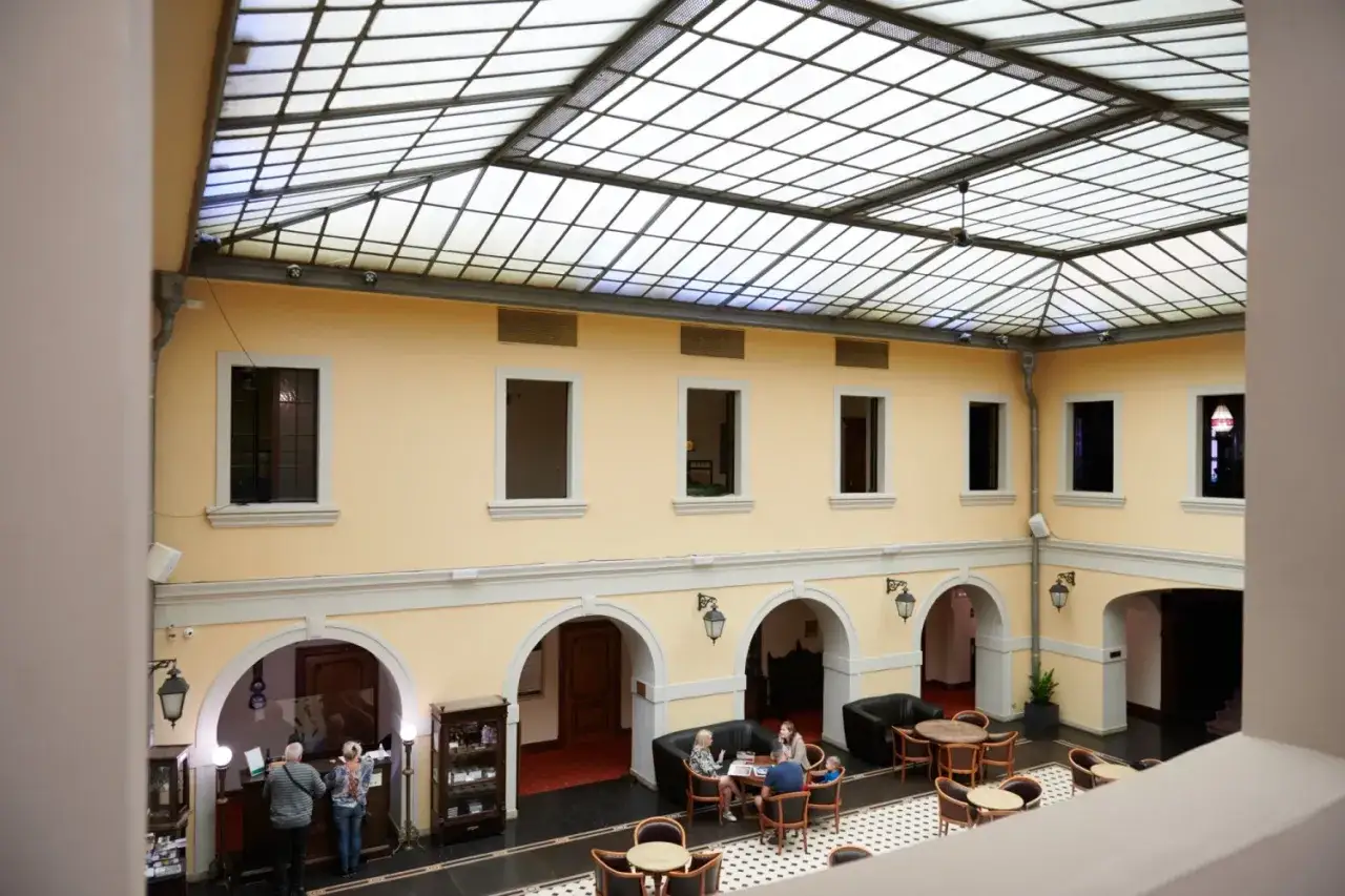 Wnętrze hotelu w stylu zamkowym w Polsce. Jasne ściany, przeszklony dach i łuki tworzą elegancką atmosferę.