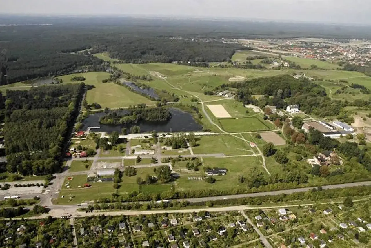 Widok z lotu ptaka na największy park miejski w Polsce, z jeziorami, lasami i zabudowaniami.