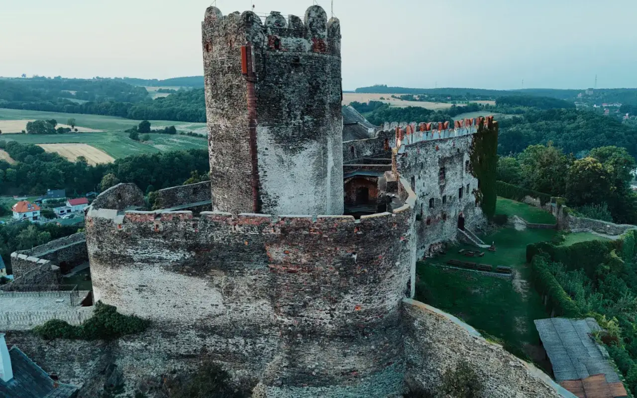 Zamek Bolków, z jego potężną wieżą i murami, otoczony zielenią. Ciekawostki o historii tego miejsca czekają na odkrycie.