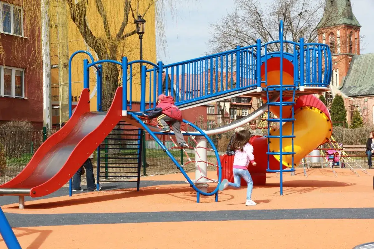 Kolorowy plac zabaw w Ełku oferuje mn&oacute;stwo atrakcji dla dzieci: zjeżdżalnie, ścianki wspinaczkowe i mn&oacute;stwo miejsca do biegania.