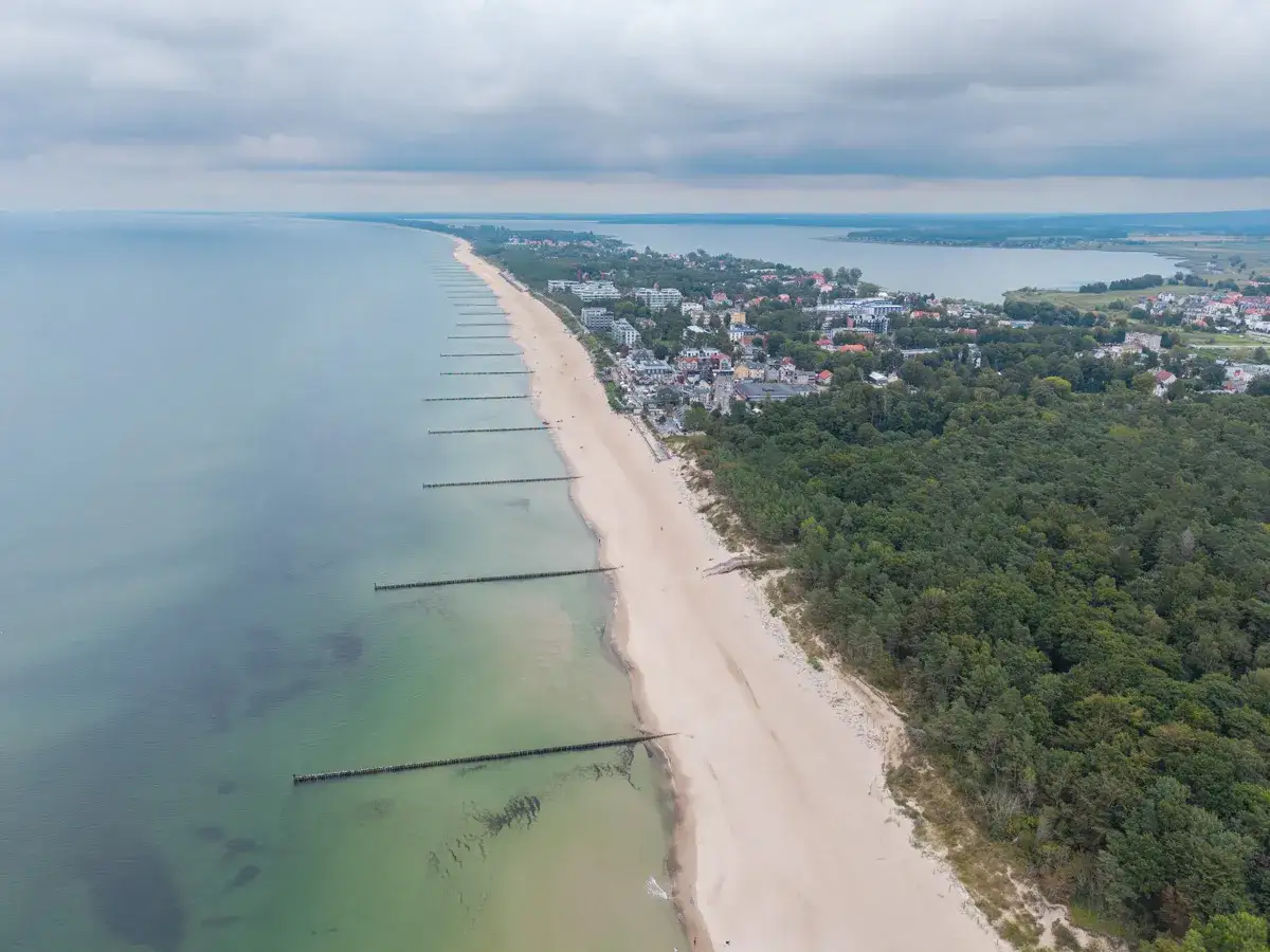 Mielno atrakcje: szeroka plaża, morze, las i zabudowania nadmorskie. Widok z lotu ptaka na wybrzeże Bałtyku.