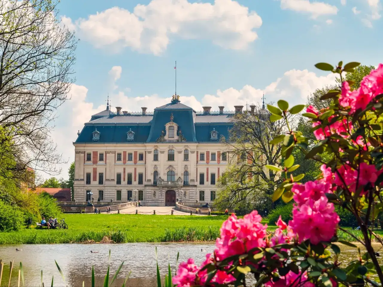 Piękny pałac otoczony zielenią i kwitnącymi rododendronami. Wiosenne ogrody kwiatowe w Polsce zachwycają.